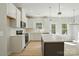 Well-lit kitchen with stainless appliances, white cabinets, gray island, and wood-look flooring at 844 Westminster Dr, Statesville, NC 28677