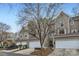 Street view of townhomes with attached garages and mature trees on a sunny day at 8904 Saint Pierre Ln, Charlotte, NC 28277