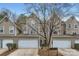 Townhouse exterior with attached garages, neutral siding, and mature trees at 8904 Saint Pierre Ln, Charlotte, NC 28277