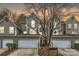 Townhouse exterior with attached garages, neutral siding, and mature trees at 8904 Saint Pierre Ln, Charlotte, NC 28277