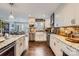 Bright kitchen featuring brick backsplash, white cabinets, stainless appliances, granite countertops, and hardwood floors at 8904 Saint Pierre Ln, Charlotte, NC 28277