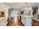 Spacious kitchen featuring hardwood floors, white cabinetry, granite countertops, a large island, and stainless steel appliances at 8904 Saint Pierre Ln, Charlotte, NC 28277