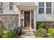 Close-up of a townhome entrance featuring stone accents and meticulously landscaped surroundings at 9108 Ainslie Downs St, Charlotte, NC 28273
