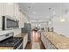 Open concept kitchen with stainless steel appliances, granite countertops, and view into the living room at 9108 Ainslie Downs St, Charlotte, NC 28273