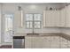 The kitchen area includes granite countertops, white cabinets, stainless steel appliances, and a sink under a window at 9108 Ainslie Downs St, Charlotte, NC 28273