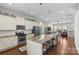 Open-concept kitchen with granite counters and island, stainless steel appliances, and view of the living room at 9108 Ainslie Downs St, Charlotte, NC 28273
