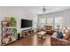 Bright living room with hardwood floors, two leather sofas, a ceiling fan, and plenty of natural light at 9108 Ainslie Downs St, Charlotte, NC 28273