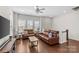 Bright living room with hardwood floors, two leather sofas, a ceiling fan, and plenty of natural light at 9108 Ainslie Downs St, Charlotte, NC 28273