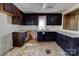 Kitchen features dark cabinets, window over sink, and worn flooring at 966 Marys Grove Rd, Cherryville, NC 28021
