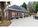 A brick home with an outdoor patio area, adorned with lush landscaping and an inviting outdoor dining set at 1038 Rolling Park Ln, Fort Mill, SC 29715