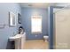 Bright blue bathroom with a pedestal sink and a tiled shower is a stylish and comfortable space at 1038 Rolling Park Ln, Fort Mill, SC 29715