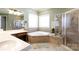 Bathroom with a walk-in shower, double sinks, corner bathtub, and natural lighting at 1038 Rolling Park Ln, Fort Mill, SC 29715