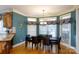 Cozy dining area with large windows, modern chandelier, hardwood floors and dark wood table at 1038 Rolling Park Ln, Fort Mill, SC 29715