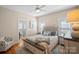 Bright bedroom with wood floors and a gray upholstered headboard boasts neutral paint at 105 Elizabeth Brook Dr, Davidson, NC 28036