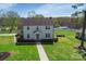 Aerial view of the two-story home featuring a manicured lawn, mature trees, and a long driveway at 113 Windsong Ct, Gastonia, NC 28056