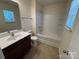 Bright bathroom featuring a single sink vanity, toilet, and shower-tub combination with tile surround at 13615 Browhill Ln, Charlotte, NC 28278
