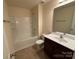 Well-lit bathroom featuring a tub/shower combo and modern vanity at 13615 Browhill Ln, Charlotte, NC 28278