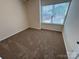 Carpeted bedroom with a window that brings in natural light, and neutral walls at 13615 Browhill Ln, Charlotte, NC 28278