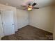 Carpeted bedroom with ceiling fan and two large doors; neutral paint at 13615 Browhill Ln, Charlotte, NC 28278