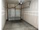 View of garage with garage door open and mechanical door lift. Walls are freshly drywalled and painted at 13615 Browhill Ln, Charlotte, NC 28278