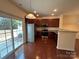 Well-lit kitchen with stainless steel appliances, dark cabinets, granite countertops, and access to a patio at 13615 Browhill Ln, Charlotte, NC 28278