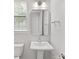 Well-lit bathroom with a pedestal sink, square mirror, modern fixtures, and tiled floors at 1409 Kenilworth Ave, Charlotte, NC 28203