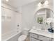 Modern bathroom with a round mirror, shower/tub combo, and bright lighting at 1409 Kenilworth Ave, Charlotte, NC 28203