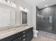 Modern bathroom features a double vanity, granite countertop and tiled walk-in shower at 1409 Kenilworth Ave, Charlotte, NC 28203