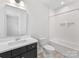 Well lit bathroom with vanity, toilet and combined tub and shower with white tiled walls at 1409 Kenilworth Ave, Charlotte, NC 28203