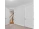 Bright bedroom with neutral carpet and white doors, offering a glimpse of the staircase at 1409 Kenilworth Ave, Charlotte, NC 28203