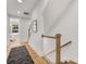 Hallway with hardwood floors, wood railing, and a gray patterned rug at 1409 Kenilworth Ave, Charlotte, NC 28203