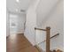 Upstairs hallway with hardwood floors, wood railing, and white trim, leading to bedrooms at 1409 Kenilworth Ave, Charlotte, NC 28203