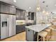 Contemporary kitchen with stainless steel refrigerator, dark cabinets, and island with barstool seating at 1409 Kenilworth Ave, Charlotte, NC 28203