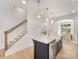Kitchen island with sink, dishwasher, and seating overlooking a staircase and dining area at 1409 Kenilworth Ave, Charlotte, NC 28203