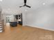 Open-concept living area with hardwood floors, modern ceiling fan, and adjacent kitchen with dark cabinetry at 1409 Kenilworth Ave, Charlotte, NC 28203
