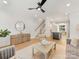 Open-concept living area with modern furnishings, hardwood floors, and seamless flow to the kitchen and staircase at 1409 Kenilworth Ave, Charlotte, NC 28203