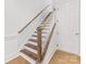 Elegant staircase with wooden treads, white risers, and a matching banister at 1409 Kenilworth Ave, Charlotte, NC 28203