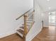Staircase with hardwood floors, wood railing, and white trim, leading to upstairs hallway at 1409 Kenilworth Ave, Charlotte, NC 28203