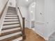 Wooden staircase with white risers and banister, leading to an upper level with a bathroom view at 1409 Kenilworth Ave, Charlotte, NC 28203