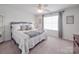 Bright bedroom featuring a comfortable bed, plush carpeting, and plenty of natural light from the window at 1411 Afternoon Sun Rd, Matthews, NC 28104