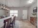 Bright dining room features a modern chandelier, hardwood floors, and a view of the front door at 1411 Afternoon Sun Rd, Matthews, NC 28104