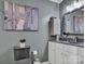 This grey-walled bathroom features a toilet, a sink, and a coastal themed art piece at 14521 Waterside Dr, Charlotte, NC 28278