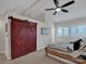 Bedroom with a barn door, fan and closet space with natural light. Windows have white shutters at 14521 Waterside Dr, Charlotte, NC 28278