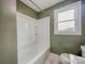 Bathroom with white tub and shower combination, complemented by stylish green paint at 176 Gravel Hill Ct, Taylorsville, NC 28681