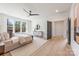 Main bedroom with hardwood floors, ceiling fan, sitting bench, and large windows at 2013 South St, Charlotte, NC 28208