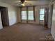 Bright living room featuring neutral walls, carpet, and ample natural light at 208 River Loop Rd, Belmont, NC 28012