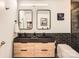 Modern bathroom with a double sink vanity, wood cabinets, and black brick accent wall at 210 N Church St # 1507, Charlotte, NC 28202