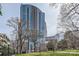 Exterior view of a modern high-rise building framed by trees at 210 N Church St # 1507, Charlotte, NC 28202