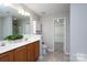 Bathroom featuring double vanity, walk-in closet access, and tile floors with functional storage options at 303 Basswood Ct, Clover, SC 29710