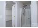 Bathroom featuring a walk-in shower with glass enclosure, a walk-in closet, and neutral walls at 303 Basswood Ct, Clover, SC 29710